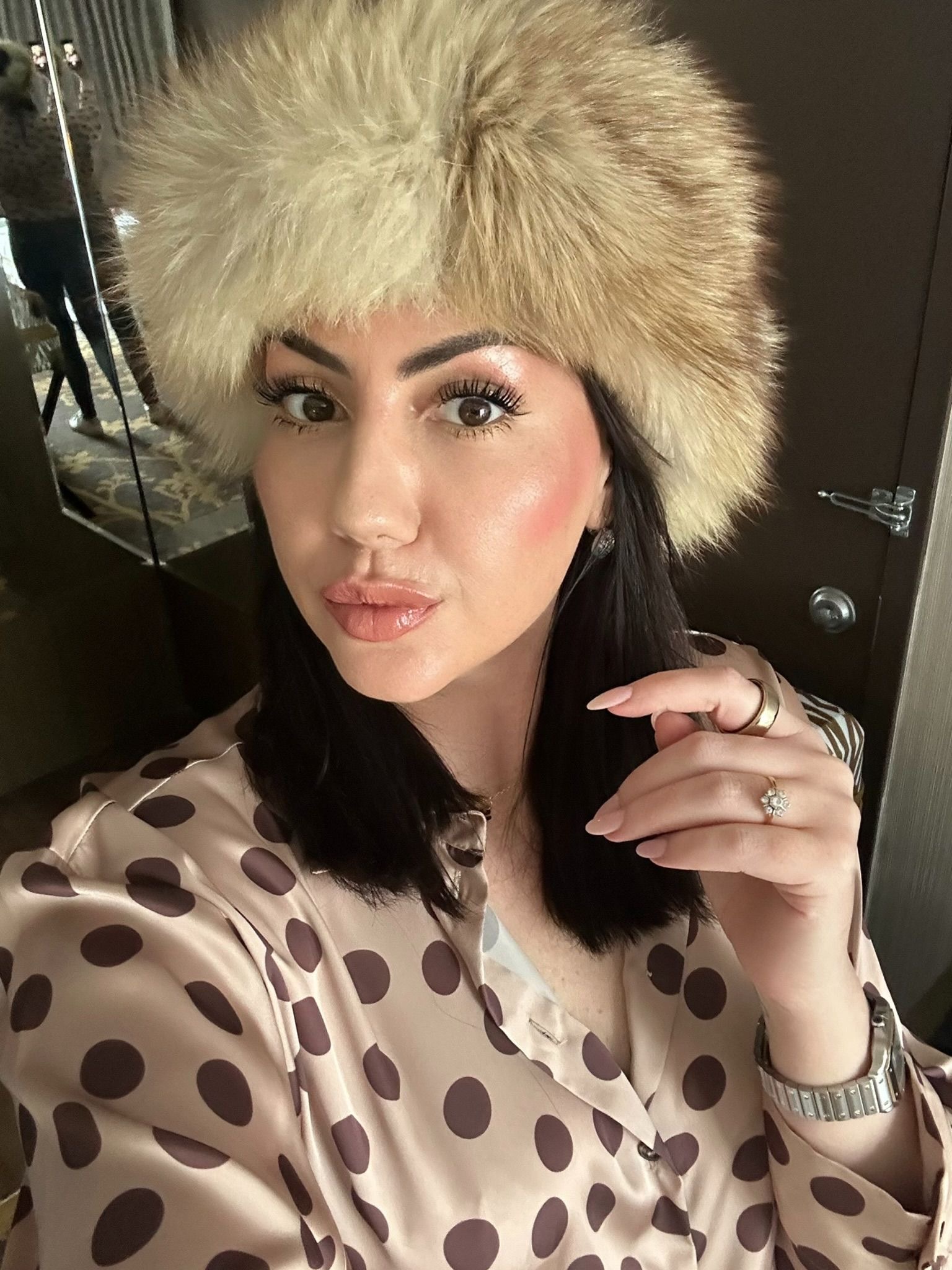 Kate wearing a fur hat and polka-dot blouse